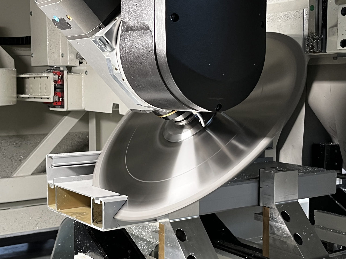 The Bolero 5 CNC machining center performing precise cutting on an aluminum profile using its high-speed blade, ideal for aerospace and construction applications.